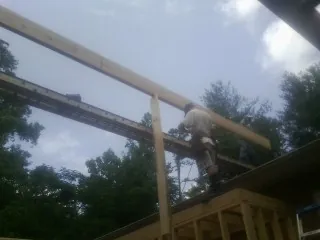 Carpenter setting a ridge beam over a new addition frame — Ice Dam Removal by Roofing Brothers in Grey Eagle