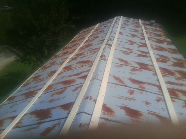 Rusted metal roof panels with new wood purlins before replacement — Storm Damage Roof Repair in Grey Eagle by Roofing Brothers