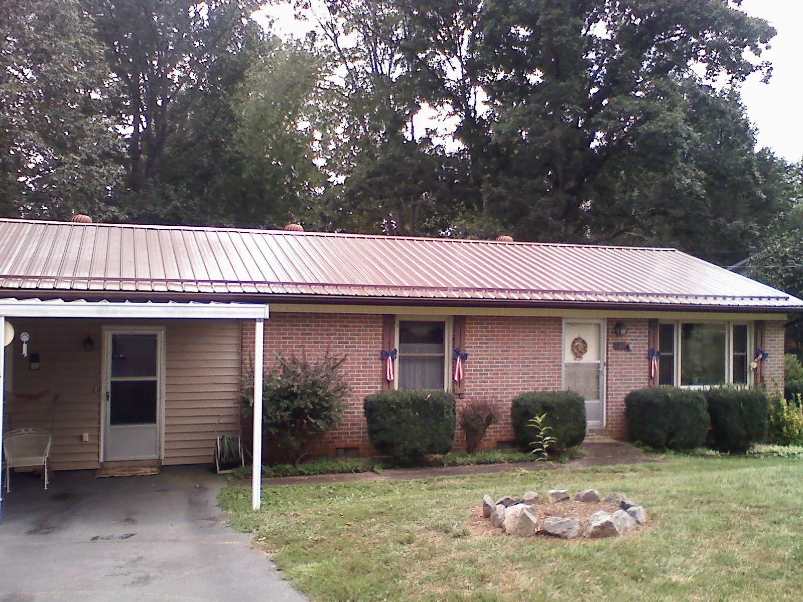 Bronze metal roof and carport on a brick ranch home — Roof Repair work by our crew in Grey Eagle
